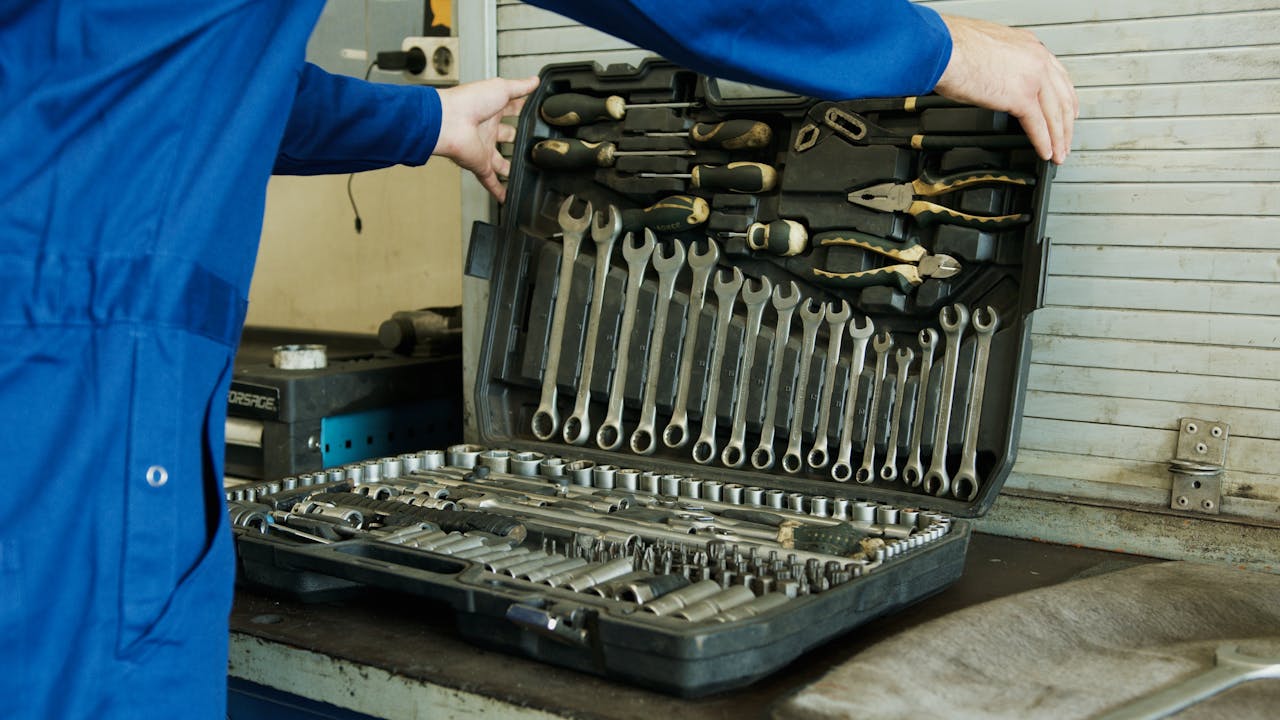 Person opening a toolbox with a set of tools