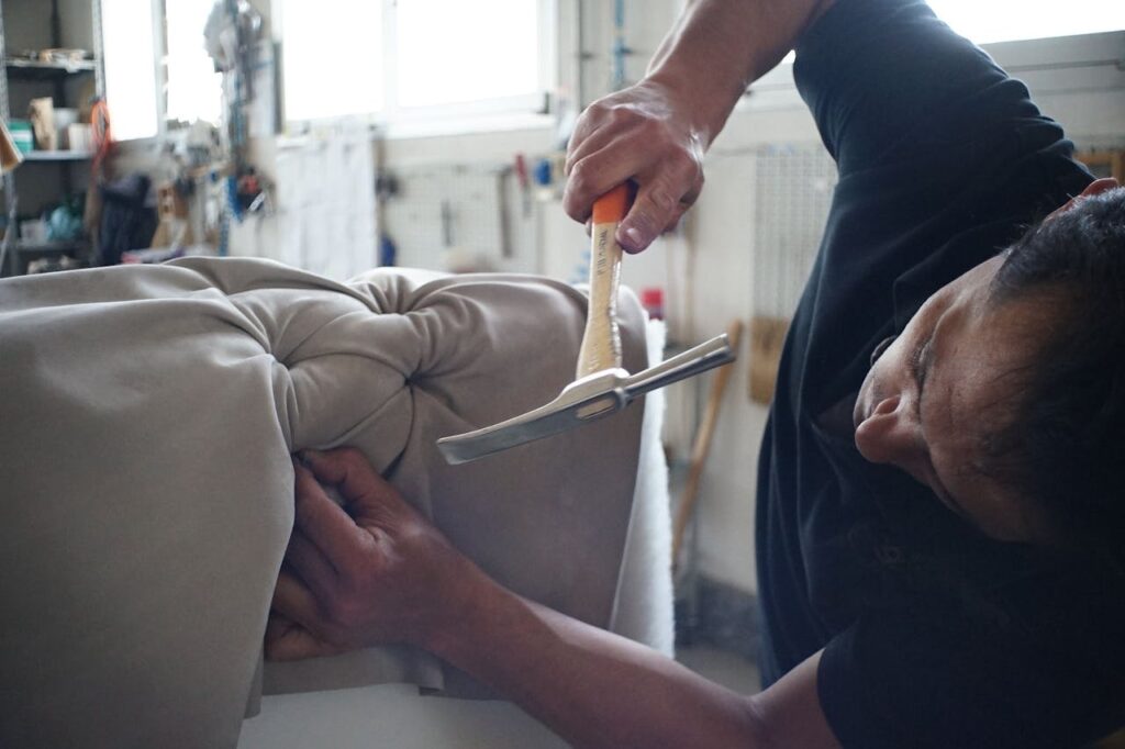 A man with a hammer restoring old furniture